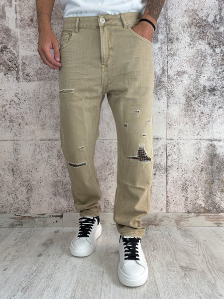 Jeans beige con rotture e toppe