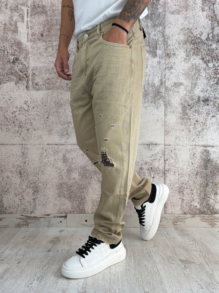 Jeans beige con rotture e toppe