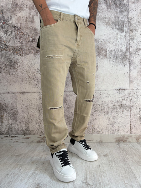 Jeans beige con rotture e toppe
