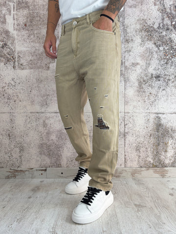 Jeans beige con rotture e toppe